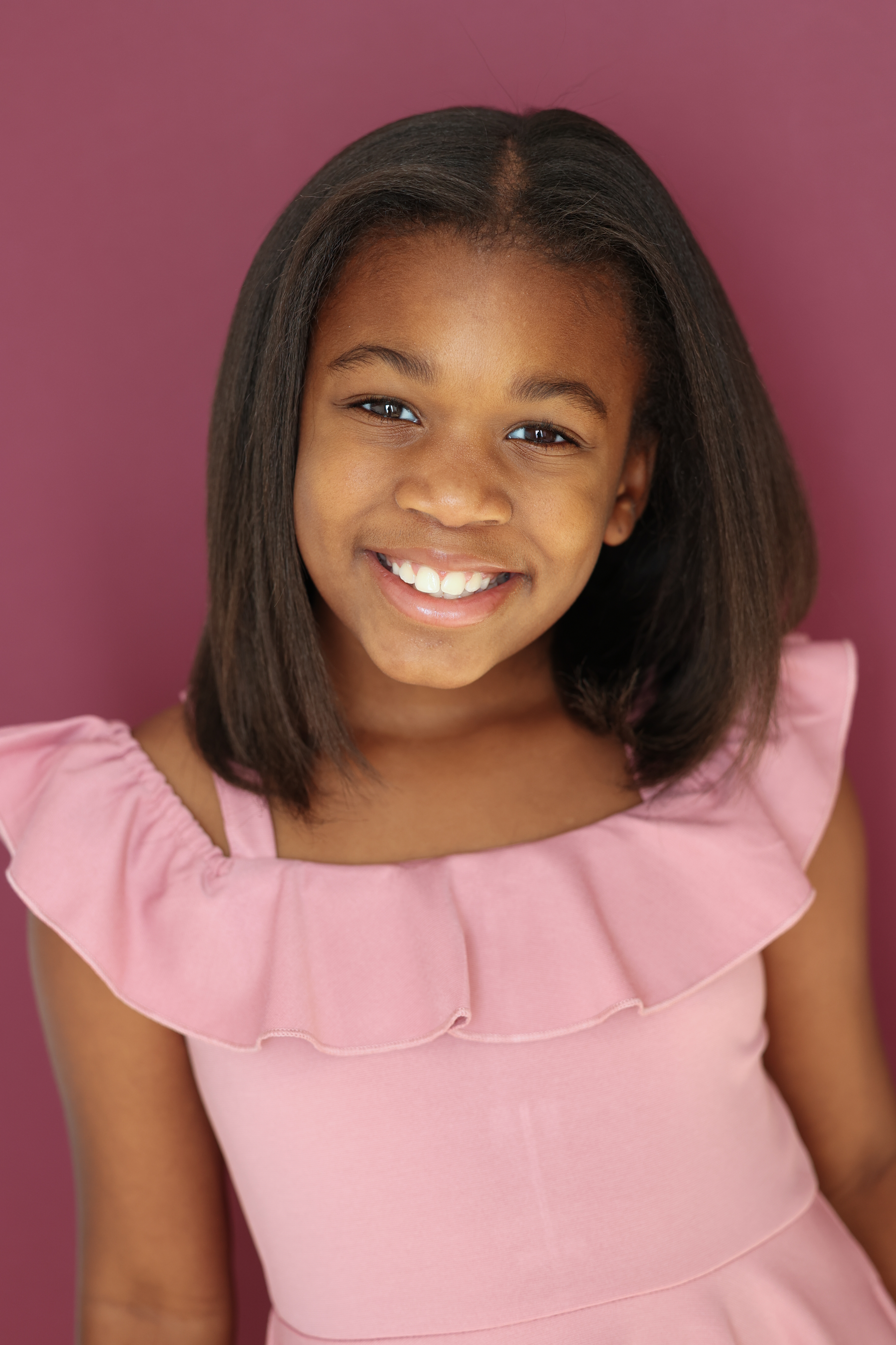 Kennedy smiling against a pink backdrop