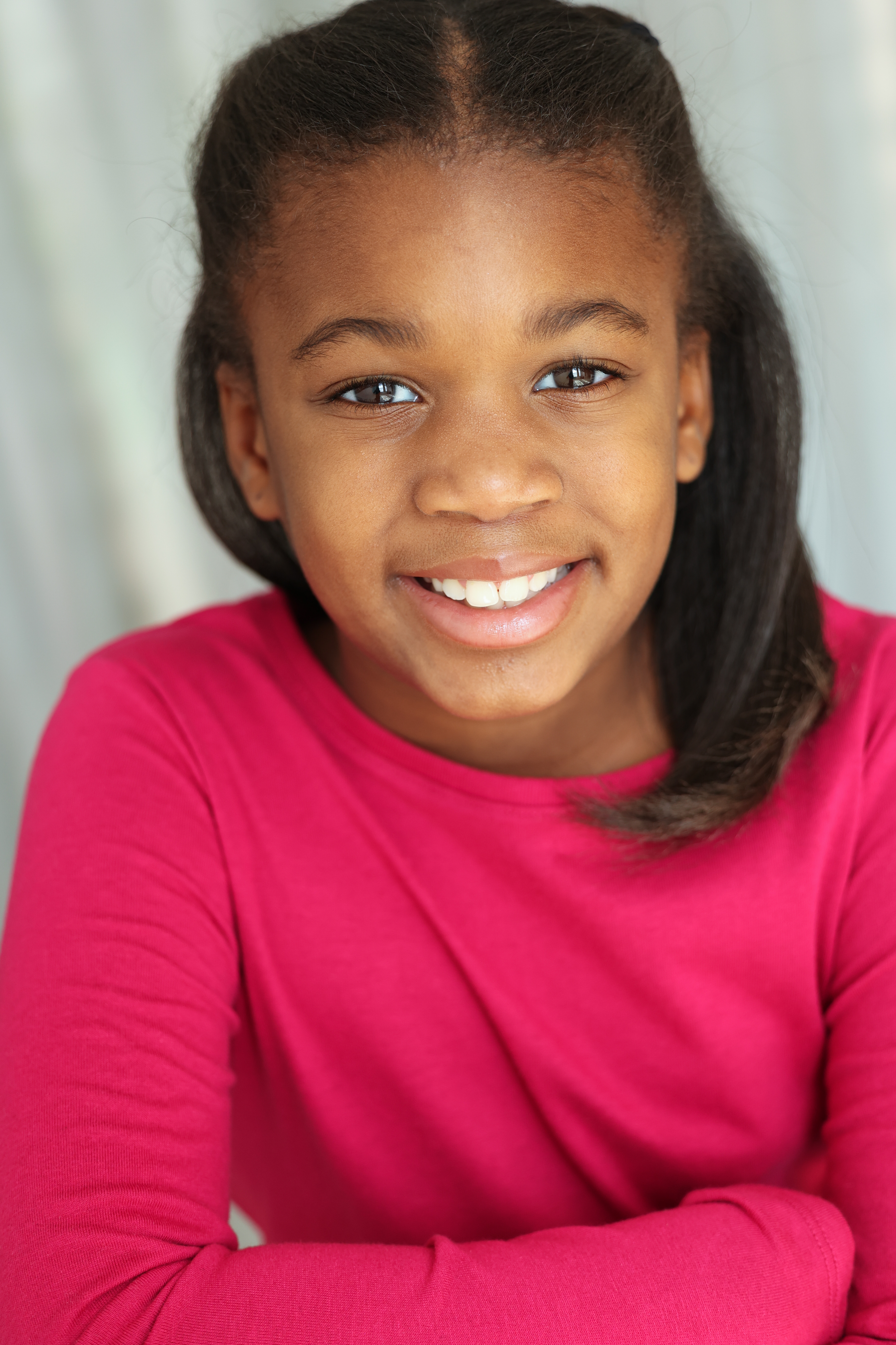 Kennedy smiling in a pink top headshot
